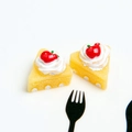 Detailed view of artificial resin cake slices with white cream and red apple accents - Yellow Apple Cake