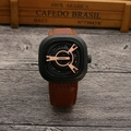 Detail view of square black punk watch with brown leather strap on dark wood - Black Case Coffee Strap