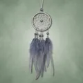 Macro detail of fluffy grey feathers and beads hanging from a dreamcatcher - Gray