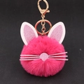 Cute pink plush kitten head keychain with glittery ears and golden metal clasp on black background - Rose Red