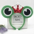Green frog headband with a small red crown for kids cosplay, shown on a white photo frame - Green Frog with Red Crown
