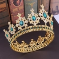 Details einer goldenen Barockkrone mit grünen Smaragden und Kristallen auf Büchern - Gold Olivgrün