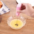 Pink handheld electric milk frother and egg beater stirring in a glass bowl - Pink Box