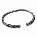 Detailed close-up of silver open cuff bracelet with intricate engraved ends in retro style - Antiqued Stainless Steel / Antique Silver