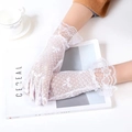 Primer plano de guantes de encaje floral blanco con bordes ondulados en revista - Blanco