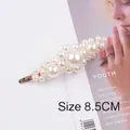 Detail showing an 8.5cm elegant pearl hair clip with gold metal base and white beads - Three Flowers