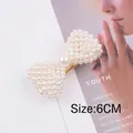 Detalle de pinza de pelo con lazo de perlas blancas de 6CM y base de metal dorado - Clip de Pico de Pato con Lazo