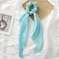 Detailopname van lichtblauwe satijnen scrunchie met lange linten op een esthetische achtergrond - Lichtblauw