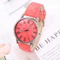 Detail of coral pink denim watch face and bronze casing with Roman numeral markers - Red