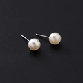 Orecchini di perle bianche classiche con perni in argento su sfondo nero testurizzato - Perla/Perno in lega / Orecchini a lobo con perle