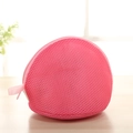 Dettaglio sacchetto a rete rosa per lavaggio reggiseni su una superficie in legno - Rosa Rosso