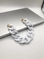 Detail of white matte acrylic chain strap with gold round spring buckles on a laptop - White
