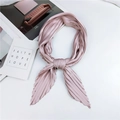 Pleated rhombic silk scarf in dusty rose pink, styled in an elegant bow on white marble - Nude