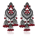 Close-up of antique silver Jhumka earrings with red gemstones and bead tassels - Red Antique Silver