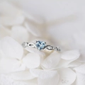 Detailed macro view of heart-shaped blue zircon stone and silver plated ring band - US 5 / Silver
