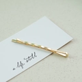 Elegant gold wavy bobby pin with pearl accent on artistic white display card - Fine Wave (3532)