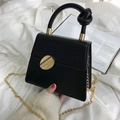 Structured black leather handbag with a unique knot handle and round gold buckle - Black