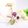 Llavero oceánico dorado con estrella de mar, concha y cristal violeta sobre una taza - Morado