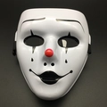 Detailed view of white clown mask with red nose and black painted facial patterns - Joker Style
