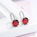 Elegant silver earrings featuring large round red zircon stones with sparkling accents - Red