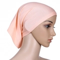 Side view of woman wearing pink mercerized cotton tube turban hat against white background - Khaki