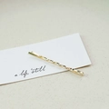 Elegant gold twisted metal hair clip with textured spiral design on art card display - Fine Twist (3535)