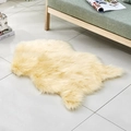 Cozy cream yellow irregular faux wool area rug on beige tiled floor by a sofa - Irregular Light Yellow
