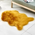 Irregular mustard yellow faux sheepskin rug on tiled floor near a sofa in home setting - Irregular Camel