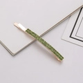 Detail shot of rectangular rose gold hair clip with double rows of green rhinestones - Light Green