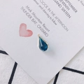 Detailed close-up of blue teardrop pendant with gold rim on a decorative card background - Malachite Green