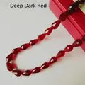 Macro shot of dark red faceted glass teardrop beads with precision cut crystal finish - 4*6mm / Crimson Red