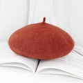 Vintage brick red wool beret hat shown in a minimalist still life on a book - M (56-58cm) / Caramel color