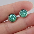 Macro shot of 8mm round blue-green druzy glitter stud earrings on a finger - Green Blue (2)