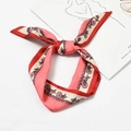 Pink and red silk scarf with horse carriage pattern tied on a book for fashion styling - Chain Grid Pink