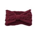 Close-up of wine red knitted headband with chunky cable knit texture and central bow knot - Fuschia