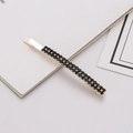 Close-up of double-row black crystal hair clip with golden base and metal alloy finish - Black