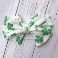Detail of white waffle texture baby headband with green shamrock clover print and bow - Clover