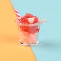 Close-up of DIY strawberry slushie resin charm with pink straw and fruit slice - Red