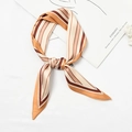 Striped silk scarf in coffee and beige tones tied in a knot on a white surface - Wide and Narrow Stripes Ginger Yellow Edge