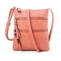 Detail view of pink leather crossbody bag with dual metal zippers and long tassel charm - Watermelon red
