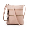 Detail of soft pink pebble leather crossbody bag featuring dual zippers and tassel pulls - Light Pink