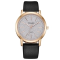 Gros plan d'un boîtier de montre or rose avec cadran pailleté argent et bracelet en cuir - Noir
