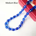 Macro detail of faceted medium blue crystal teardrop beads for DIY jewelry making - 3*5mm / Medium Blue & White
