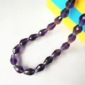Close-up of faceted violet glass teardrop beads for DIY jewelry and decor projects - 4*6mm / Violet