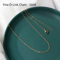 Dettaglio di una sottile catena a O dorata con chiusura a moschettone su piatto verde - Catena O Sottile / 45 cm / Oro