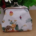 Close-up of vintage floral canvas coin purse with silver kiss-lock metal clasp detail - White