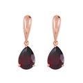 Dettaglio di orecchini in oro rosa con pietre di granato rosso con taglio a goccia - Rosso