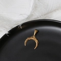 Dettaglio del ciondolo a mezzaluna dorata con incisione tribale in ciotola nera - Mezzaluna Pop Oro