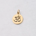 Detalle macro del colgante de yoga Om dorado con diseño calado y anilla de conexión - 12*17mm / Dorado