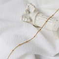 Dettaglio di collana a catena a sfere dorate su elegante sfondo decorativo bianco - Catena a Sfere / 45 cm / Oro